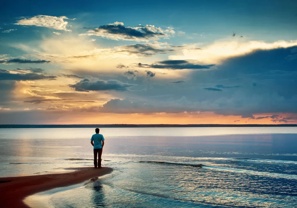 Man looking into clouds over the sea